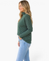 Beach Rose Co. green micro-stripe turtleneck top with dropped shoulders worn by a blonde model in profile view