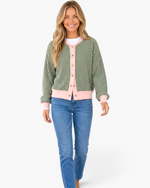 Beach Rose Co. green striped cardigan with pink trim, snap-front closure, and long sleeves worn with blue jeans.