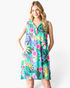 Beach Rose Co. green sleeveless swing dress with a vibrant tropical floral print, notched V-neck, and side pockets.