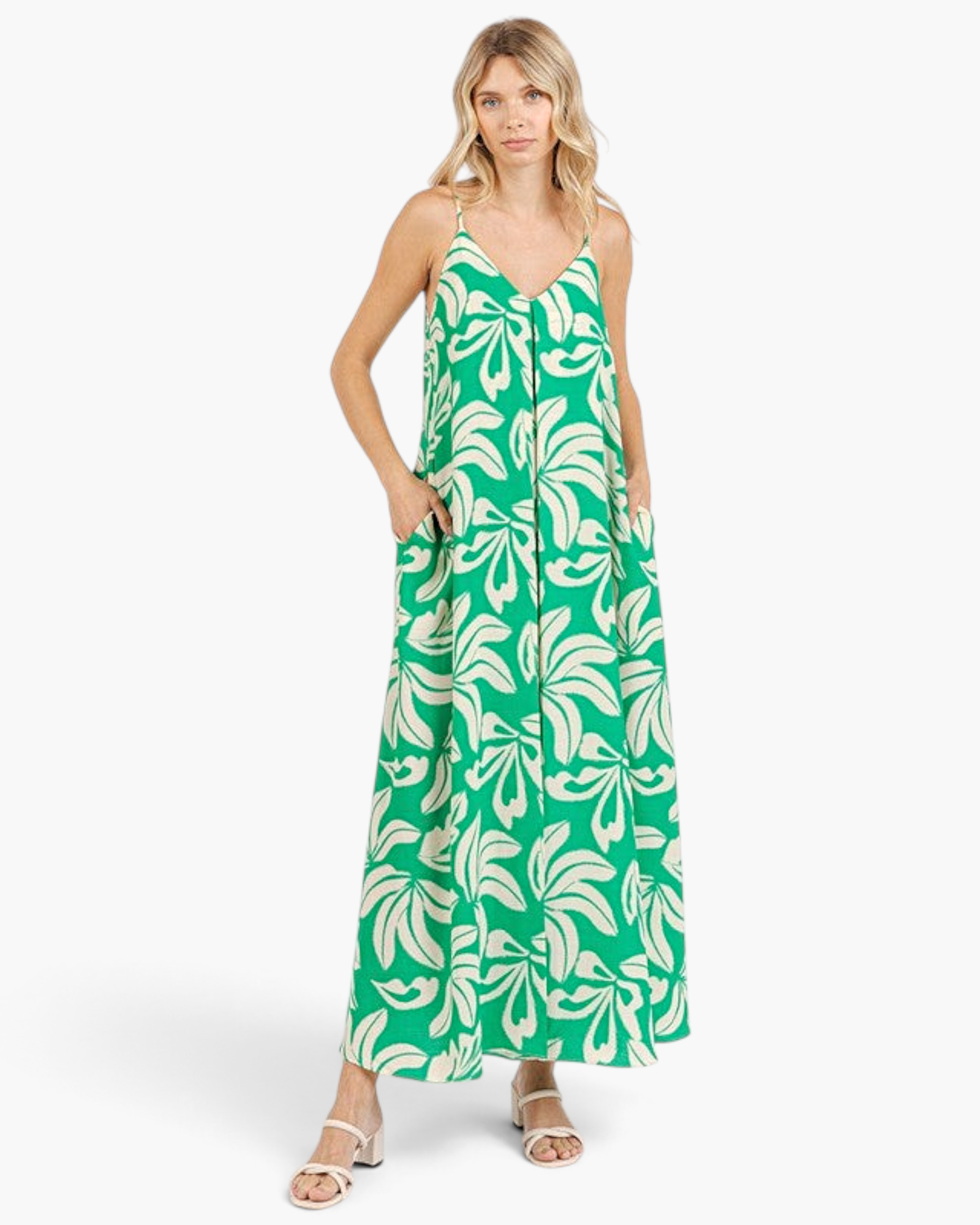 Beach Rose Co. green maxi dress with ivory tropical leaf print, V-neckline, and side pockets on a blonde model.