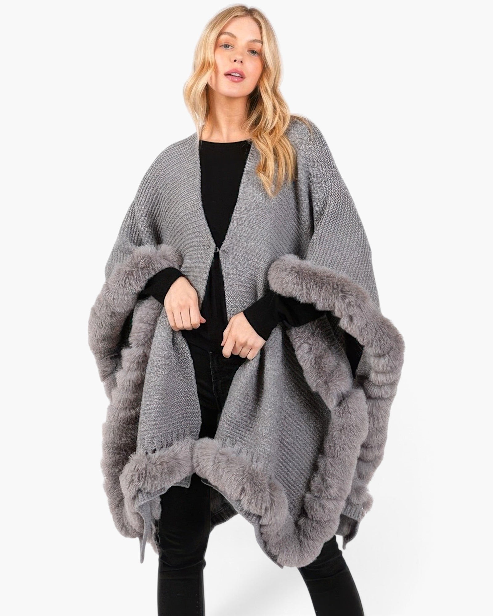 Beach Rose Co. grey knit cape with plush faux fur trim and front clasp closure worn by a blonde model.