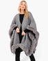Beach Rose Co. grey knit cape with plush faux fur trim and front clasp closure worn by a blonde model.