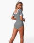 Beach Rose Co. grey short-sleeve one-piece swimsuit with white contrast trim on the scoop back and sleeve cuffs