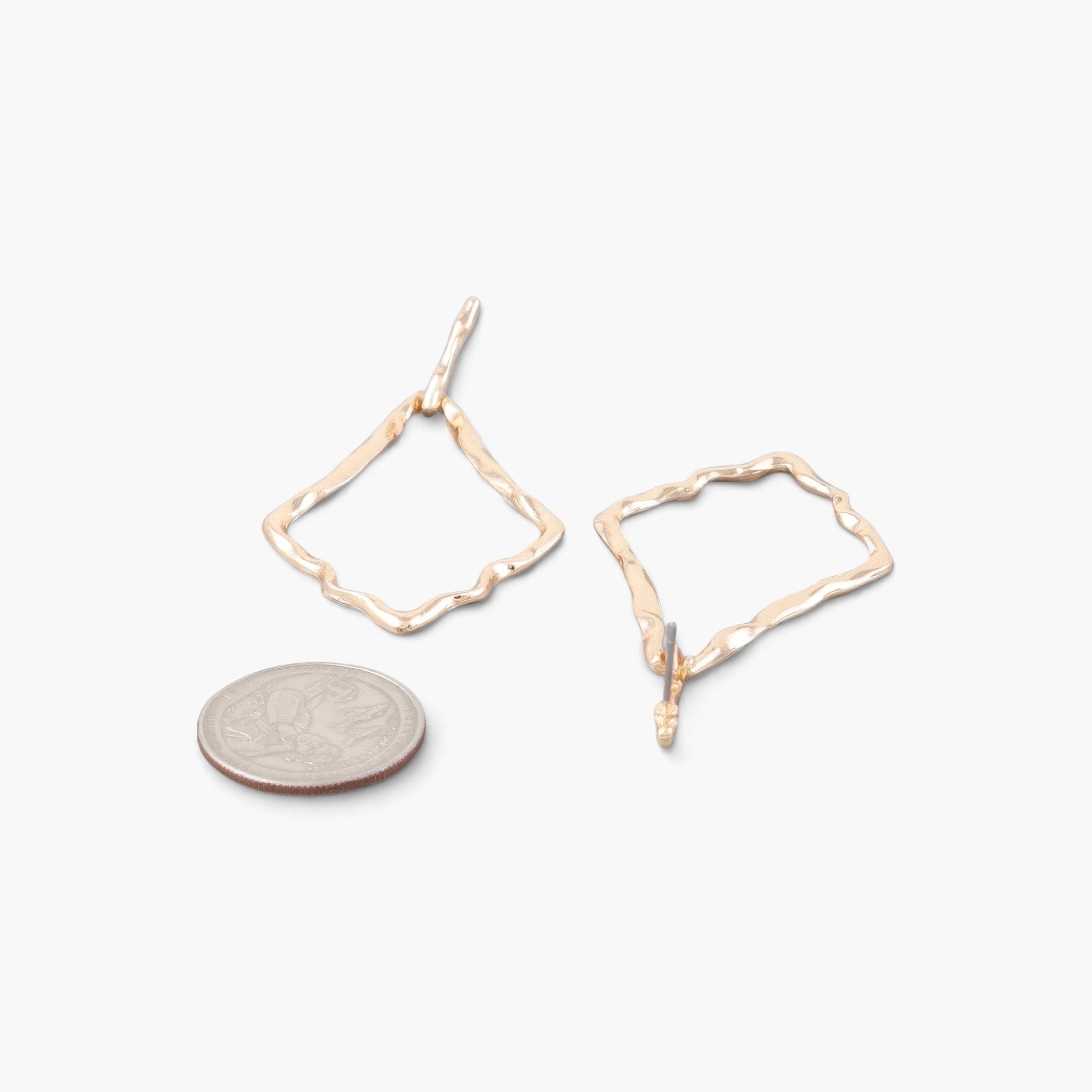 Beach Rose Co. gold-tone kite-shaped earrings with a hammered texture, shown next to a coin for size reference.