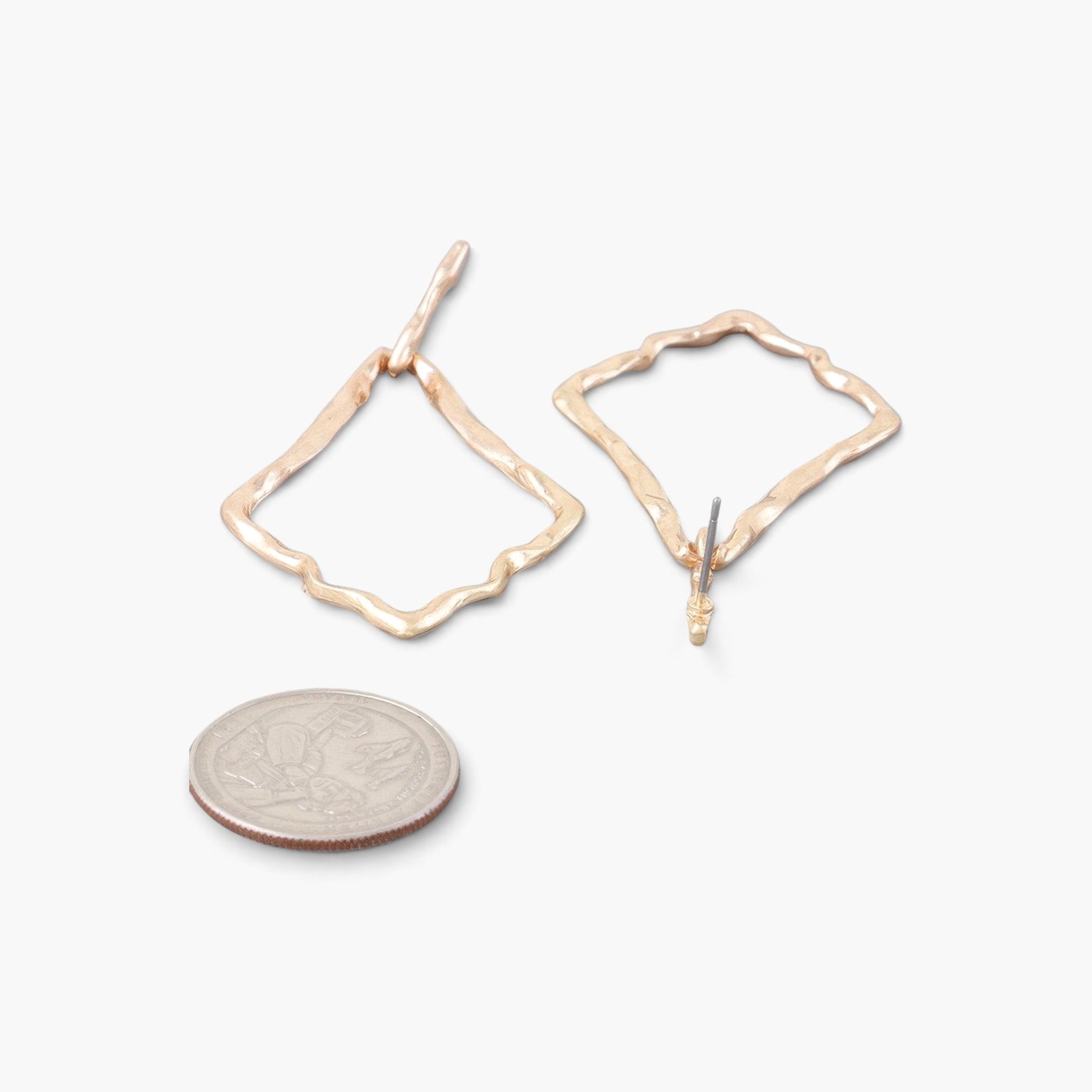 Beach Rose Co. shiny gold-tone hammered kite-shaped drop earrings with a textured finish next to a US quarter coin.