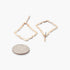 Beach Rose Co. shiny gold-tone hammered kite-shaped drop earrings with a textured finish next to a US quarter coin.