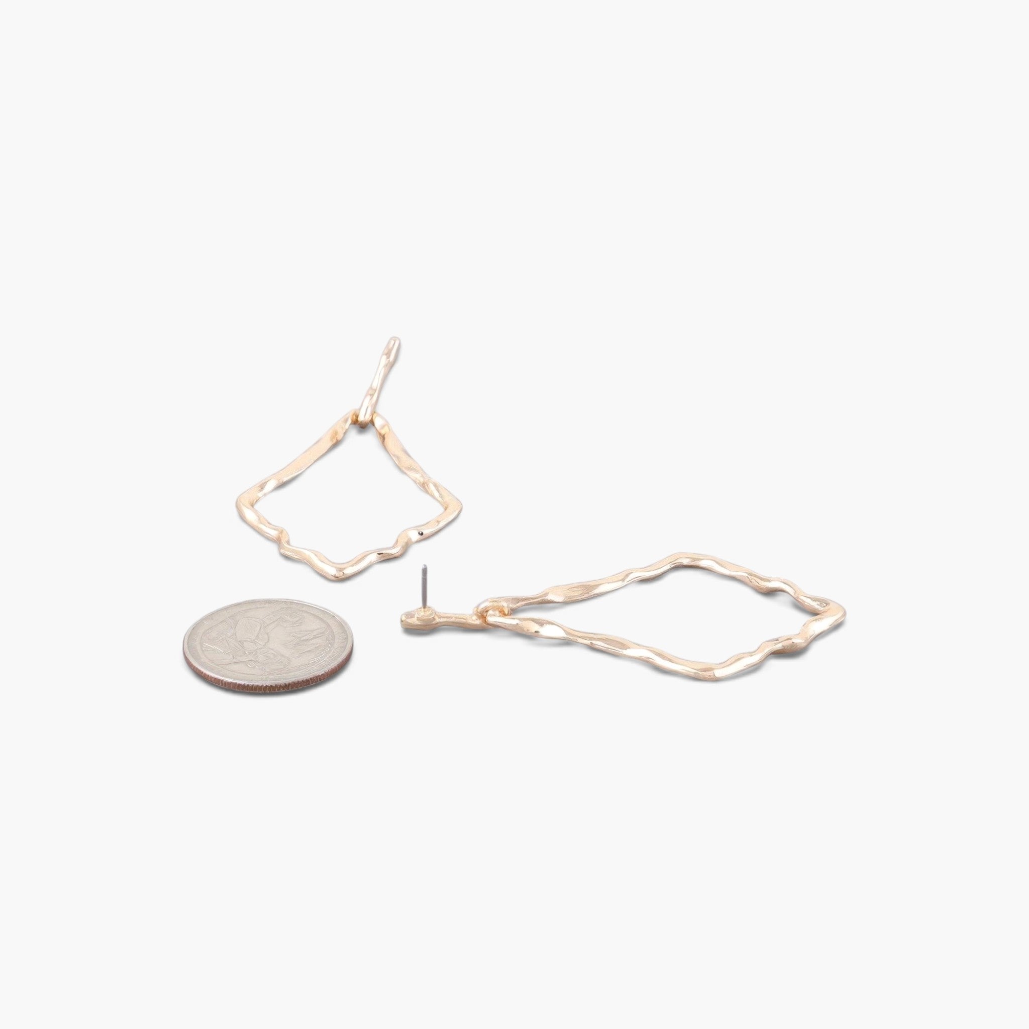 Beach Rose Co. gold-tone kite-shaped earrings with a hammered texture, shown next to a coin for size reference.