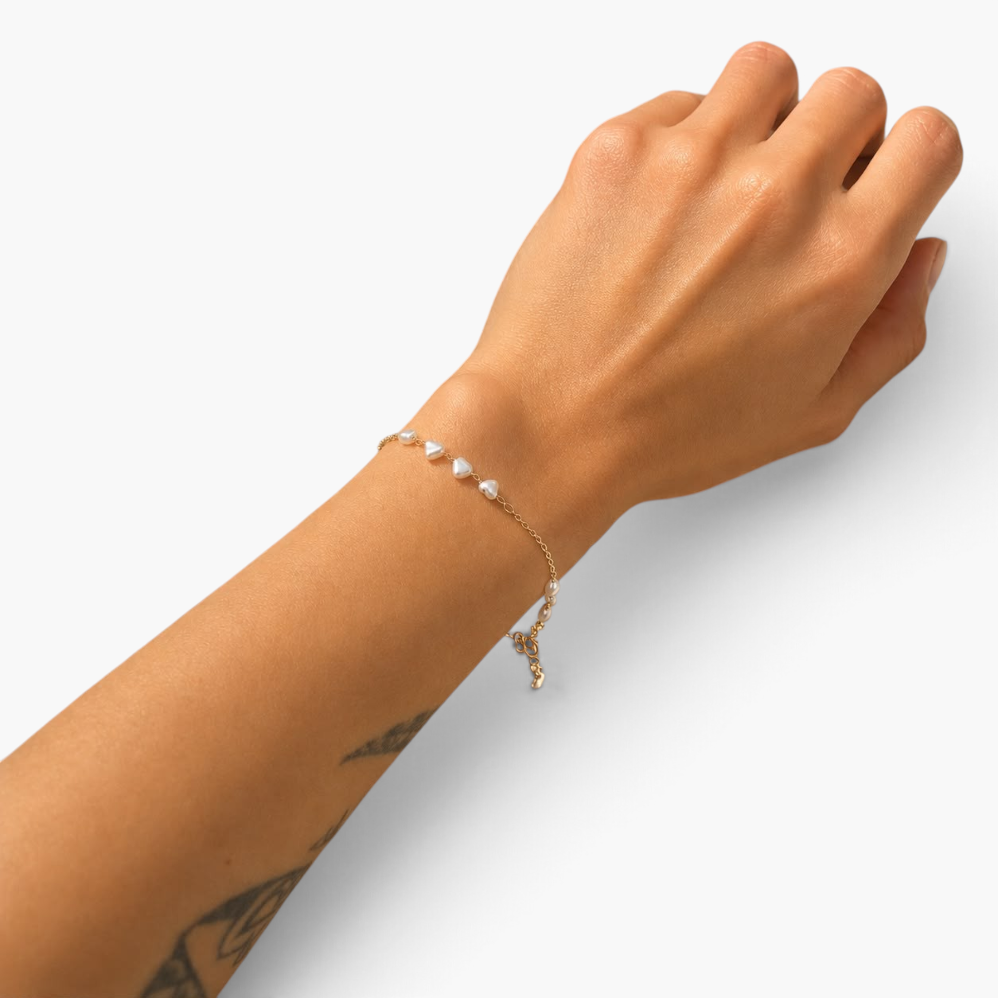 Beach Rose Co. delicate 18K gold filled bracelet featuring heart-shaped pearl beads on a thin chain on a wrist