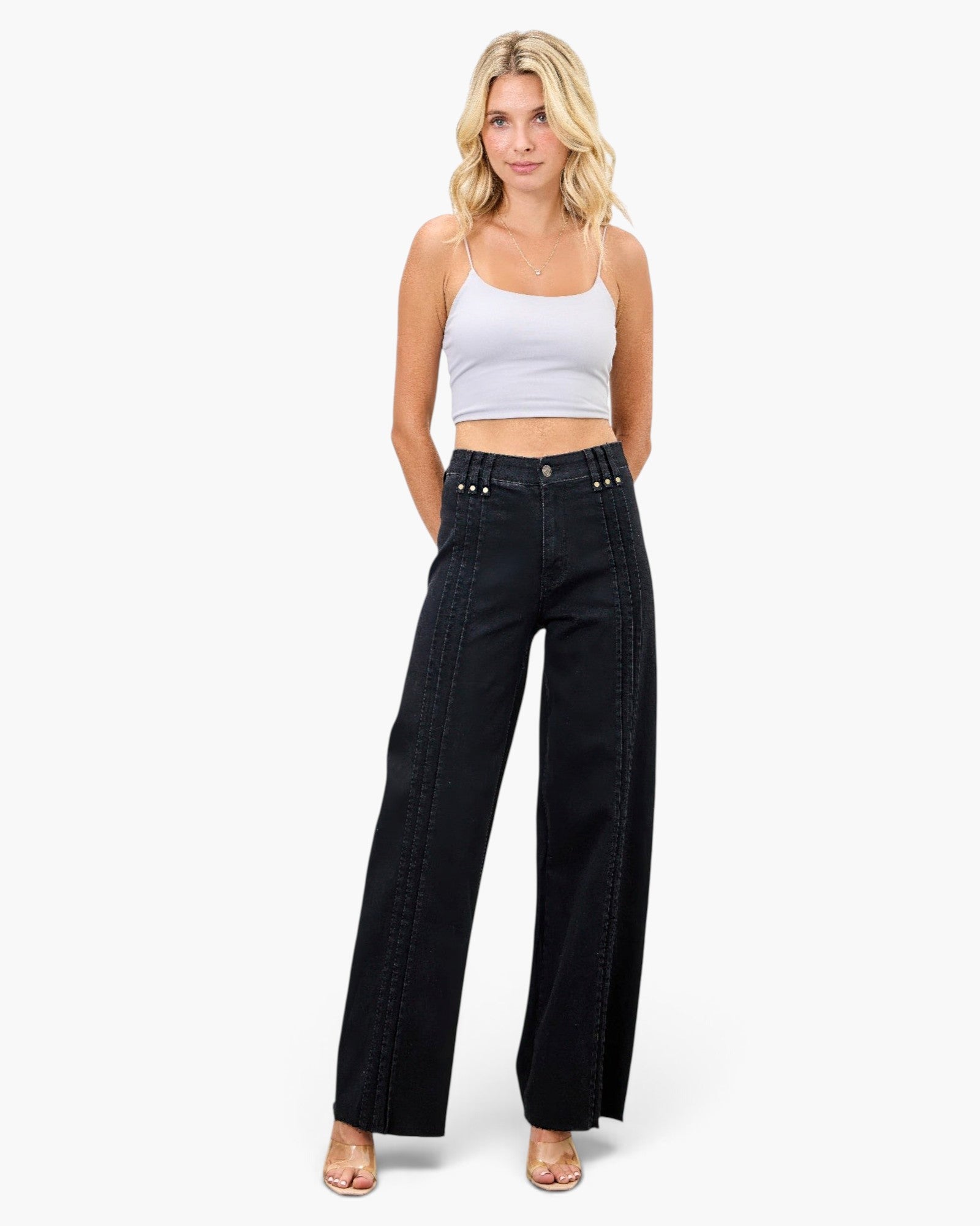 Beach Rose Co. high-rise straight-leg black jeans with front pleat detailing worn by a blonde model in a white top.