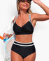 Beach Rose Co. black and white two-piece high-waisted bikini with a cross-front top and contrasting trim details.