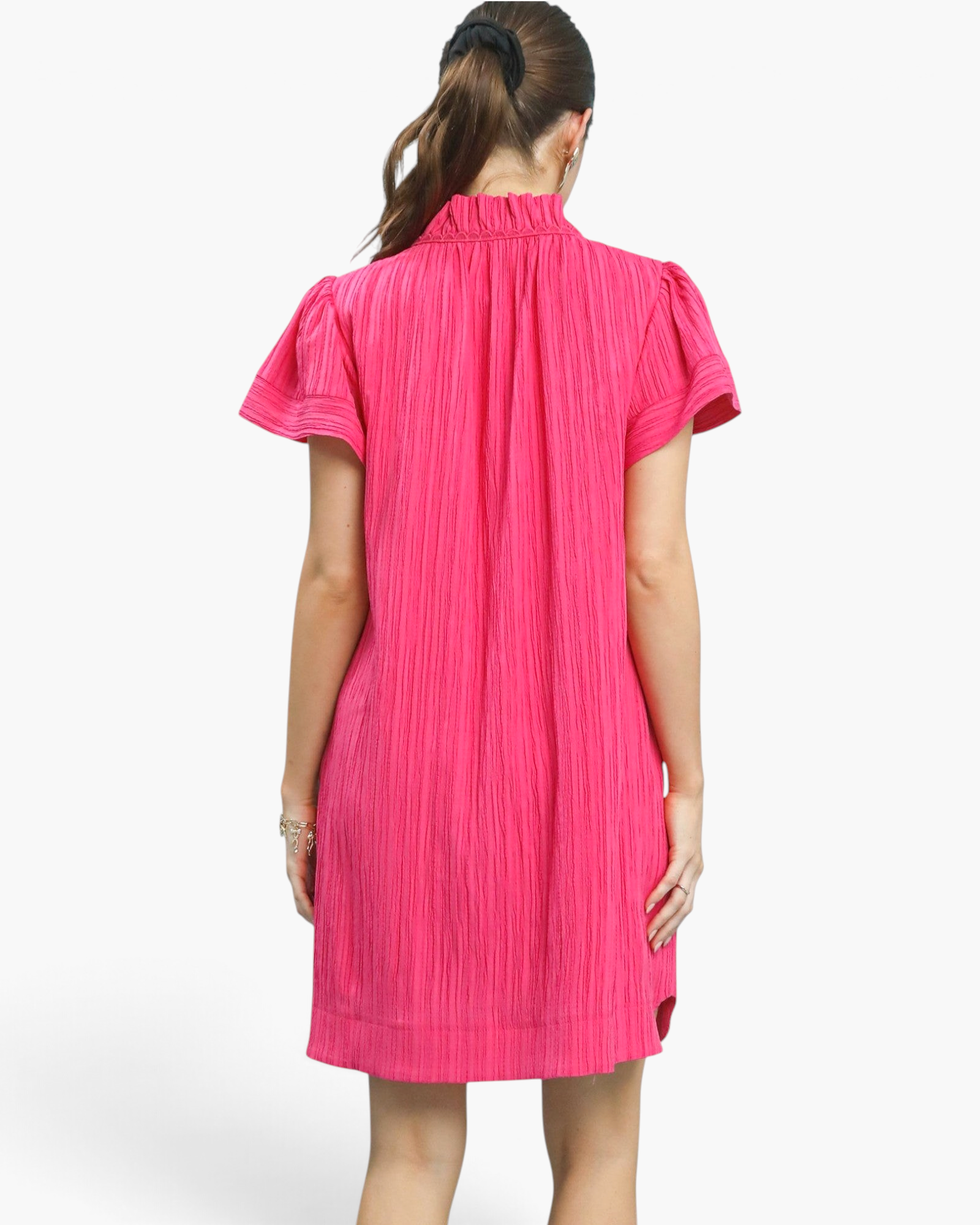 Back view of a Beach Rose Co. hot pink textured shift dress with a ruffled collar and gathered short sleeves.