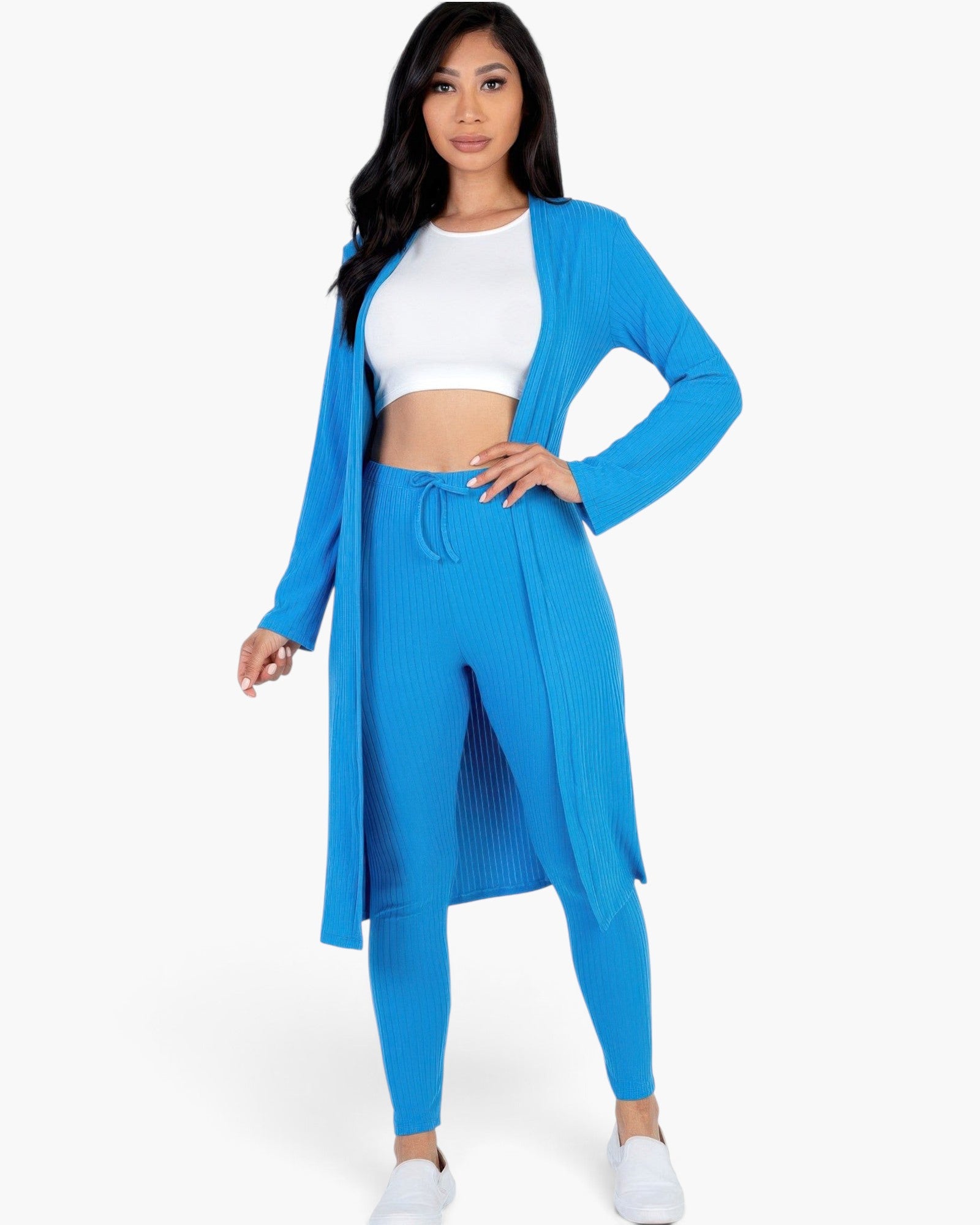 Beach Rose Co. model wearing a vibrant Ibiza blue ribbed long cardigan and matching leggings set over a white crop top.