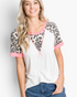 Beach Rose Co. ivory top with leopard print raglan sleeves, pink trim, and a relaxed fit worn by a smiling woman.