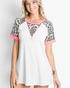 Beach Rose Co. ivory raglan top with leopard print sleeves, pink trim, and a relaxed fit worn by a smiling woman.