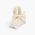 Beach Rose Co. ivory nylon clutch featuring a large front bow and a gathered scrunchie-style top handle.
