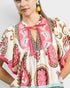 Beach Rose Co. Ivory and pink paisley border print rayon top with split neckline and tie detail.