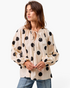Beach Rose Co. ivory cotton top with black polka dots, featuring a gathered tie-neck and long balloon sleeves.