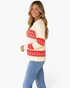 Beach Rose Co. ivory cable knit sweater with red Fair Isle patterns worn by a smiling woman with long blonde hair