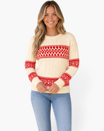 Beach Rose Co. ivory cable knit sweater with red Fair Isle patterns worn by a smiling woman with blonde hair.