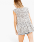 Beach Rose Co. ivory tiered top with black spotted print, flutter sleeves, and a relaxed flowing silhouette