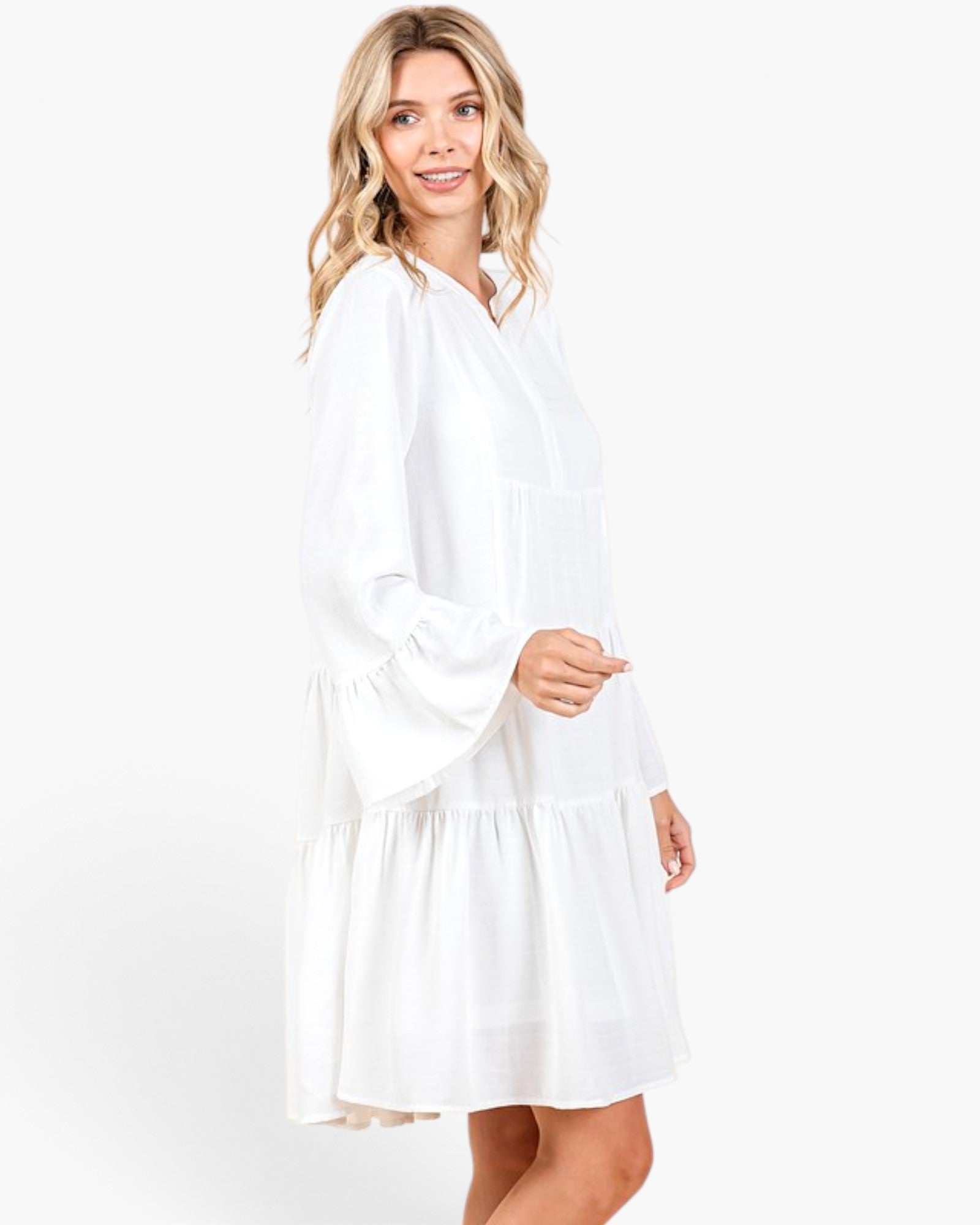 Beach Rose Co. ivory tiered shift dress with long bell sleeves and a split neckline worn by a blonde model