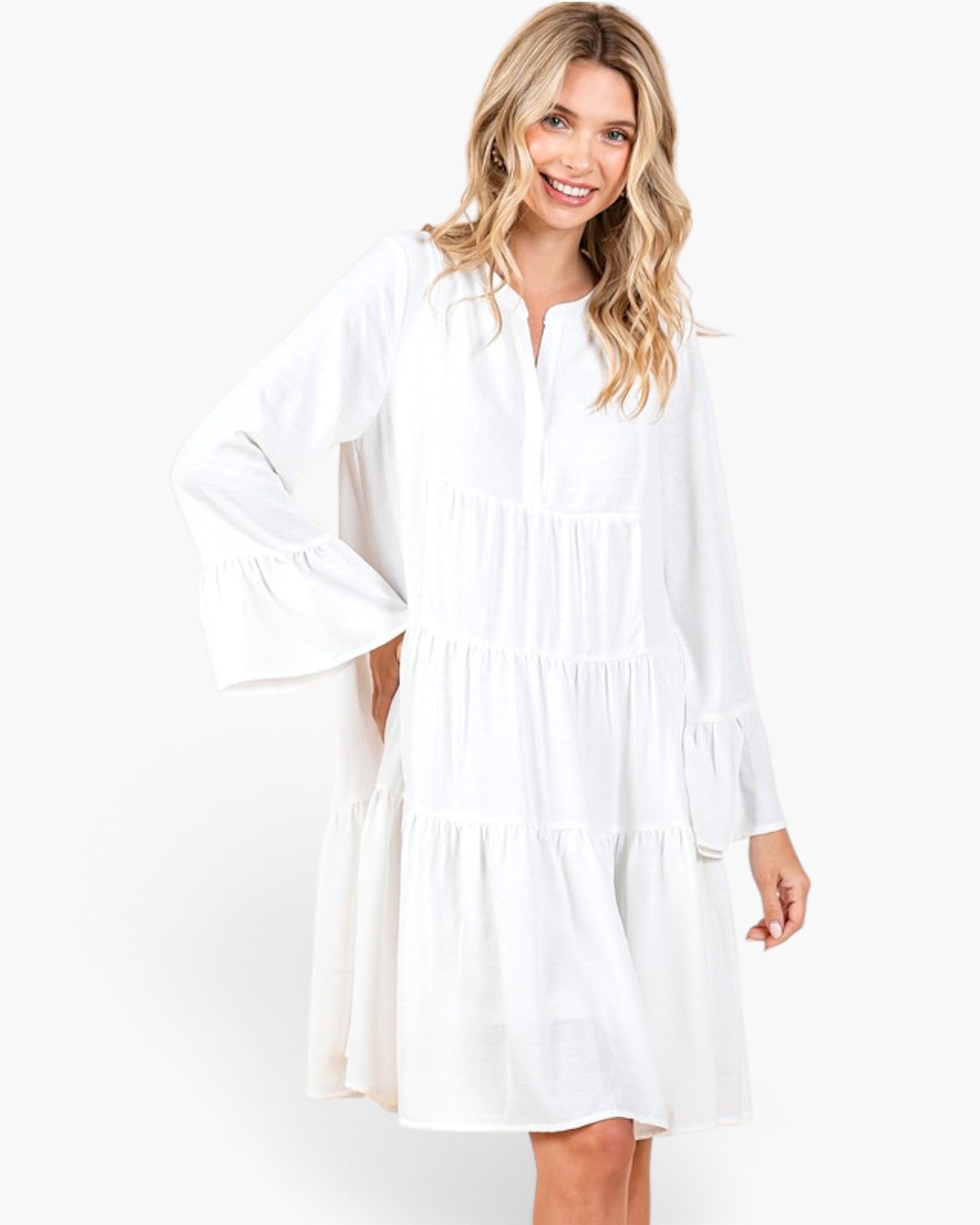 Beach Rose Co. ivory tiered shift dress with long bell sleeves and a split neckline worn by a smiling blonde model.