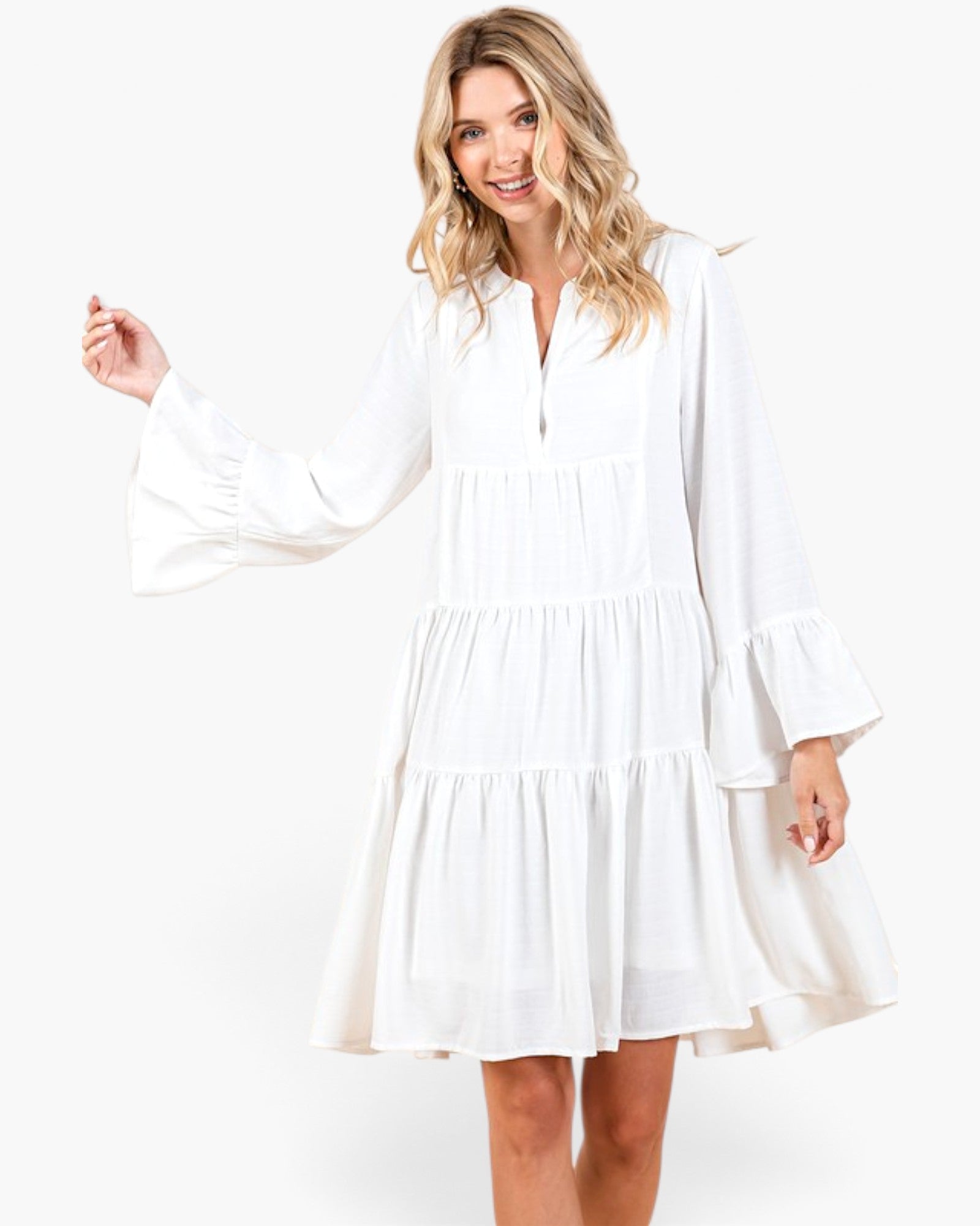 Beach Rose Co. ivory tiered shift dress with long bell sleeves and a split neckline on a smiling blonde model