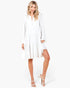 Beach Rose Co. ivory tiered shift dress with long bell sleeves and a split neckline worn by a blonde model