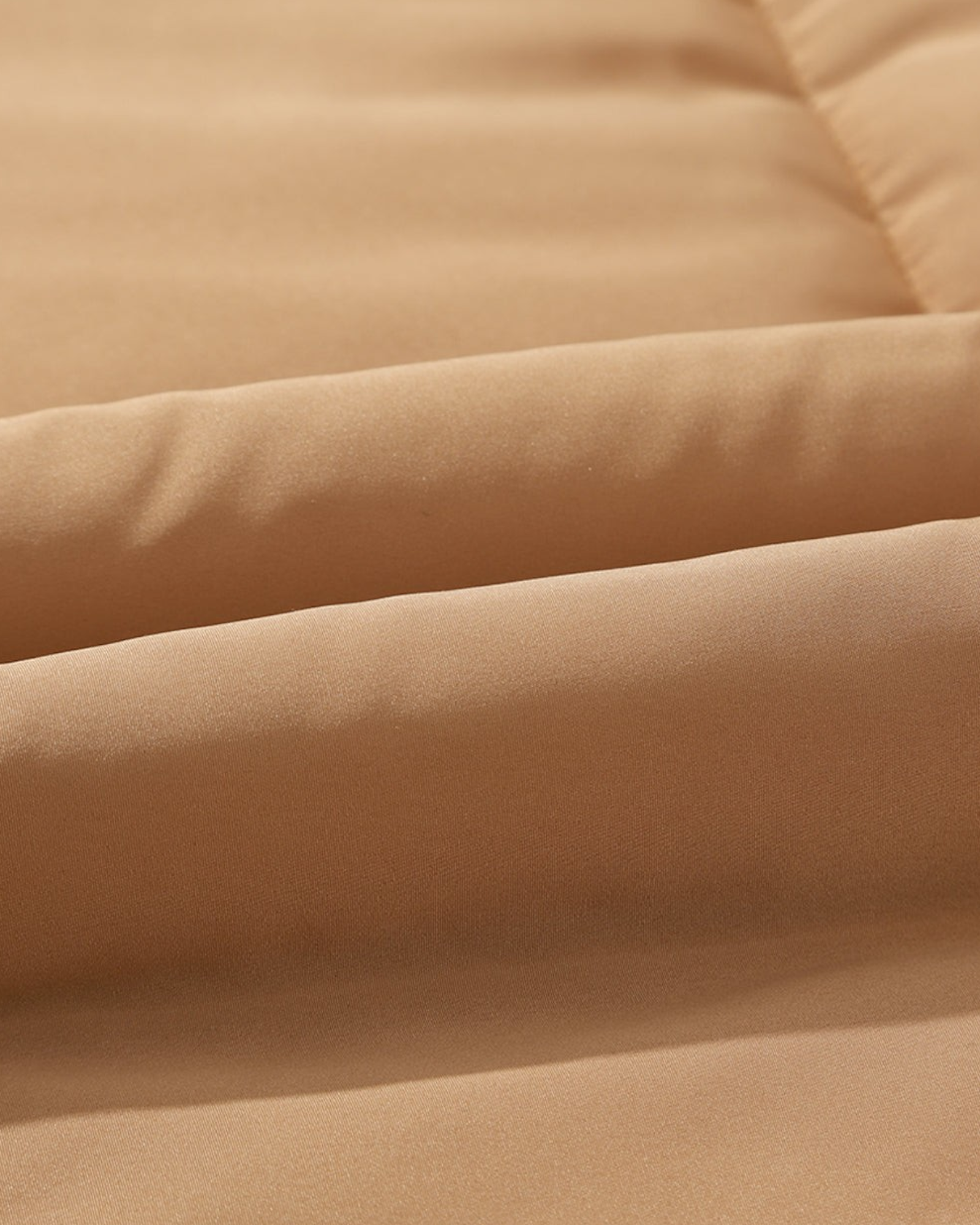 Close-up of the smooth khaki polyester fabric on a Beach Rose Co. quilted puffer vest.