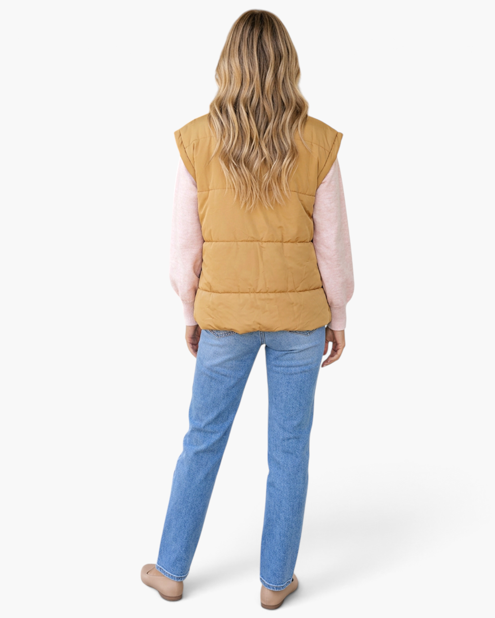 Beach Rose Co. khaki quilted puffer vest worn over a pink sweater and blue jeans, back view