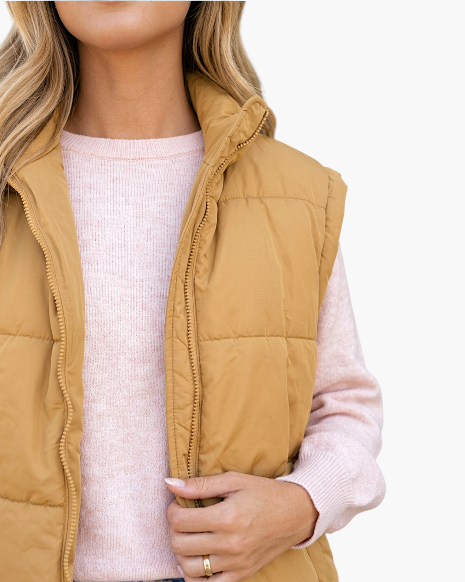 Beach Rose Co. khaki quilted puffer vest with a stand collar and full zip front worn over a light pink sweater.