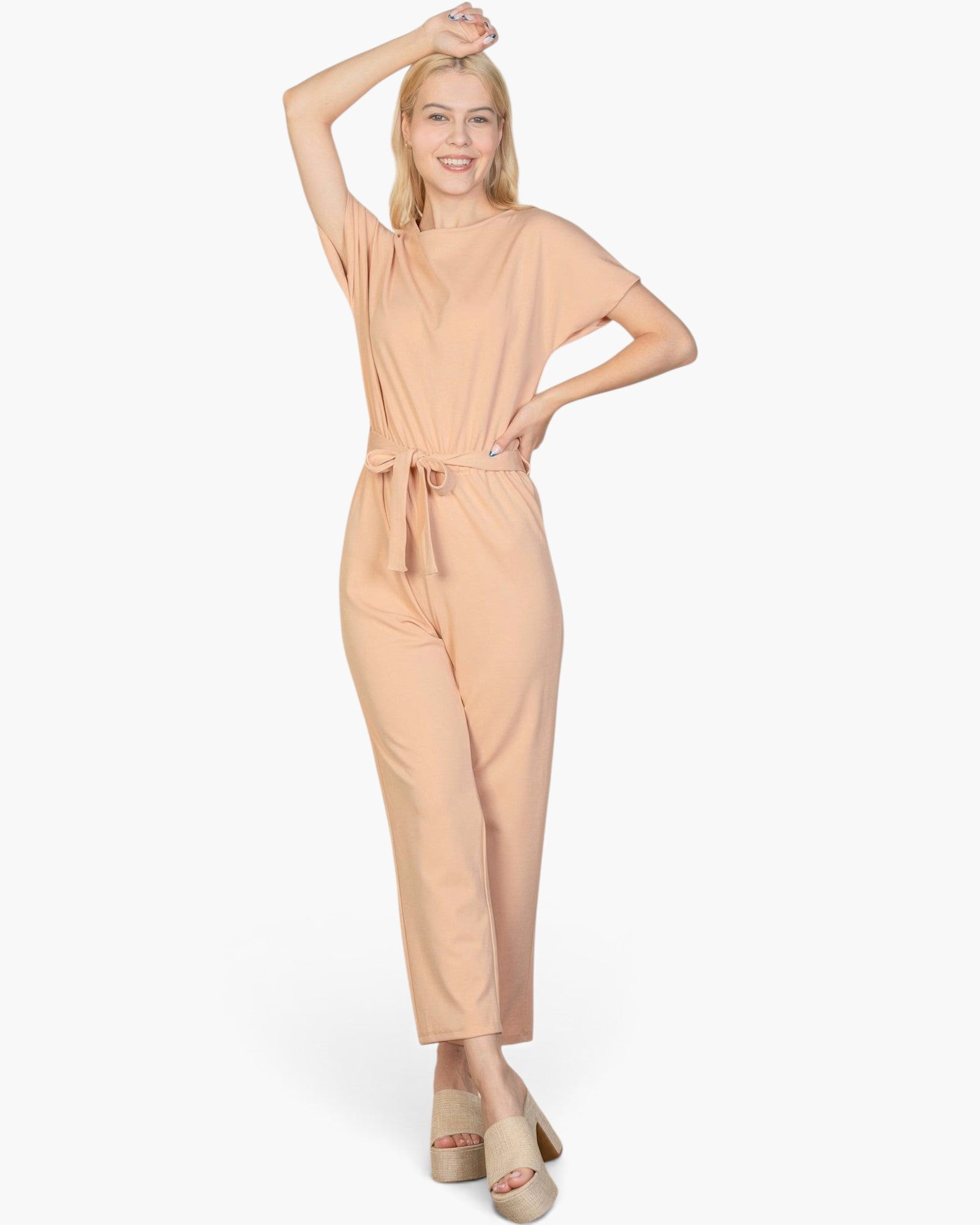 Beach Rose Co. model wearing a khaki relaxed rib knit jumpsuit with a tie waist and short sleeves.