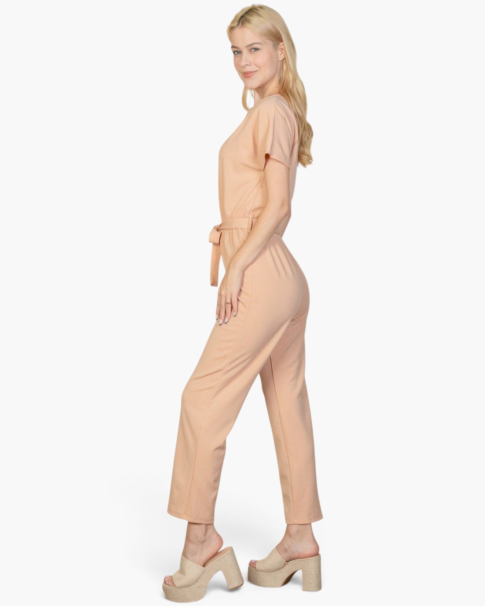 Beach Rose Co. model wearing a khaki tie waist relaxed jumpsuit in soft rib knit fabric, side profile view.