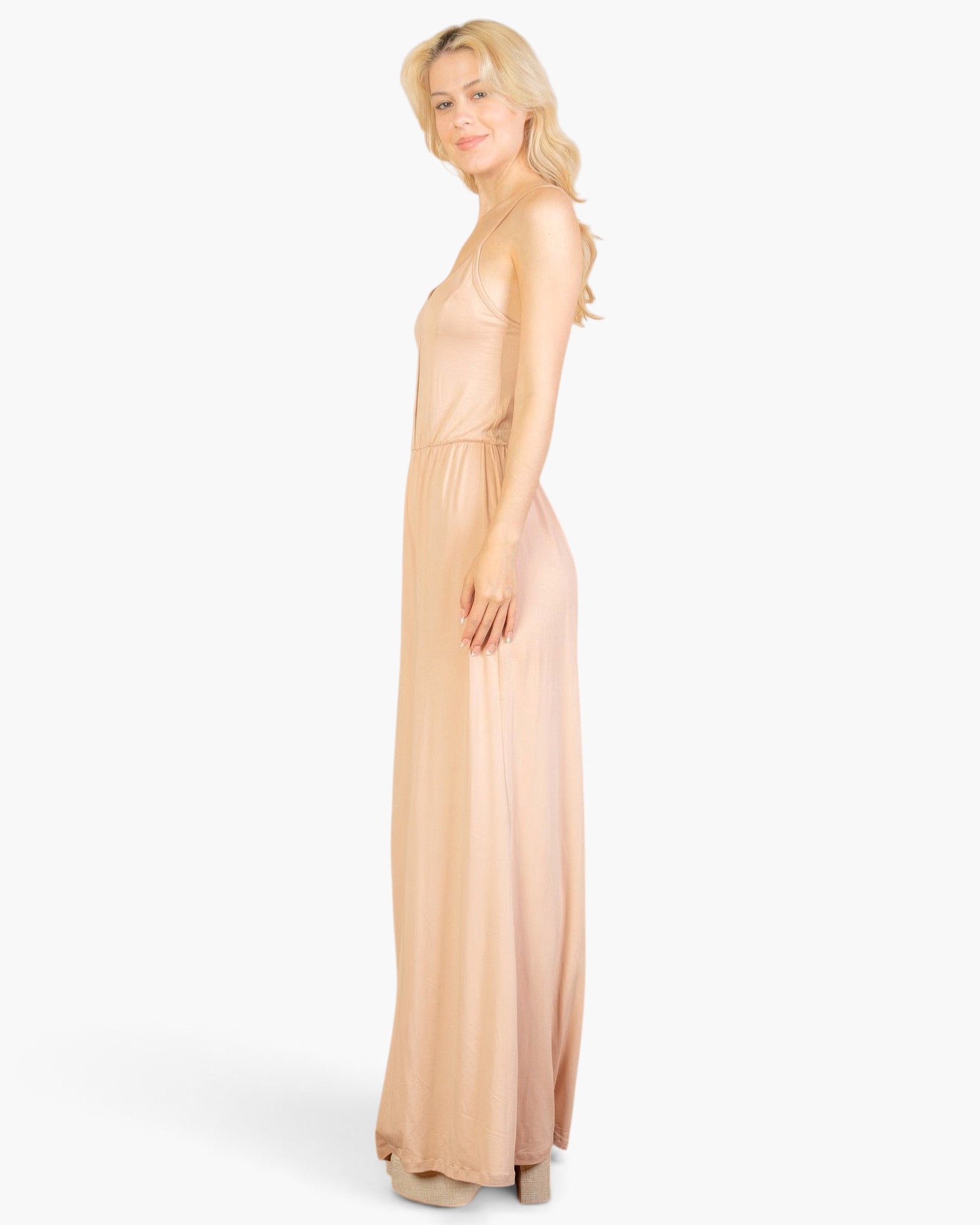 Beach Rose Co. model wearing a khaki button-front wide-leg jumpsuit in soft stretch jersey fabric, side view
