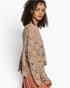 Beach Rose Co. latte open-knit crochet long sleeve top with scalloped edges worn by a model in a relaxed fit.