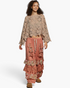 Beach Rose Co. latte open-knit crochet long sleeve top with scalloped edges worn by a model with curly hair