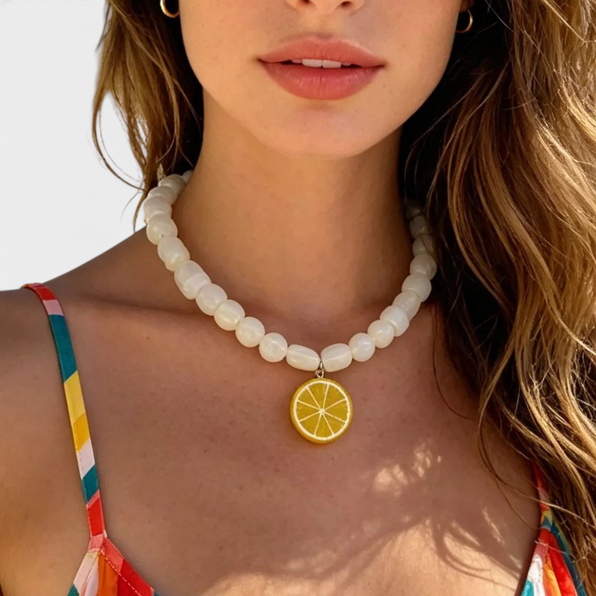 Beach Rose Co. necklace featuring glossy white resin beads and a yellow lemon slice pendant on a model