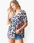 Beach Rose Co. multicolor leopard print babydoll top with a crisscross V-neckline and short sleeves on a model.