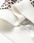 Beach Rose Co. ivory ribbed cuff detail on a leopard print long-sleeve top made from soft stretch fabric.