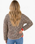 Back view of a woman wearing a Beach Rose Co. beige and black leopard print diamond-quilted jacket with beige trim.