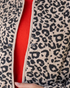 Beach Rose Co. beige and black leopard print quilted snap-front jacket with beige trim worn over a red sweater
