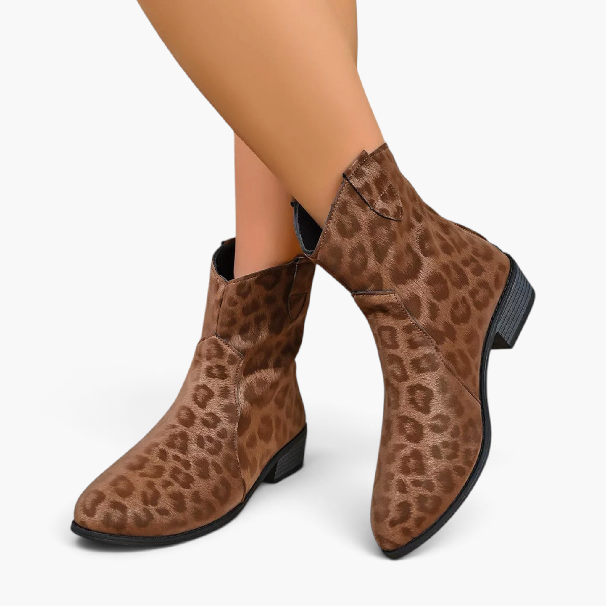 Beach Rose Co. leopard print suede western ankle boots with a low block heel and curved shaft on a model