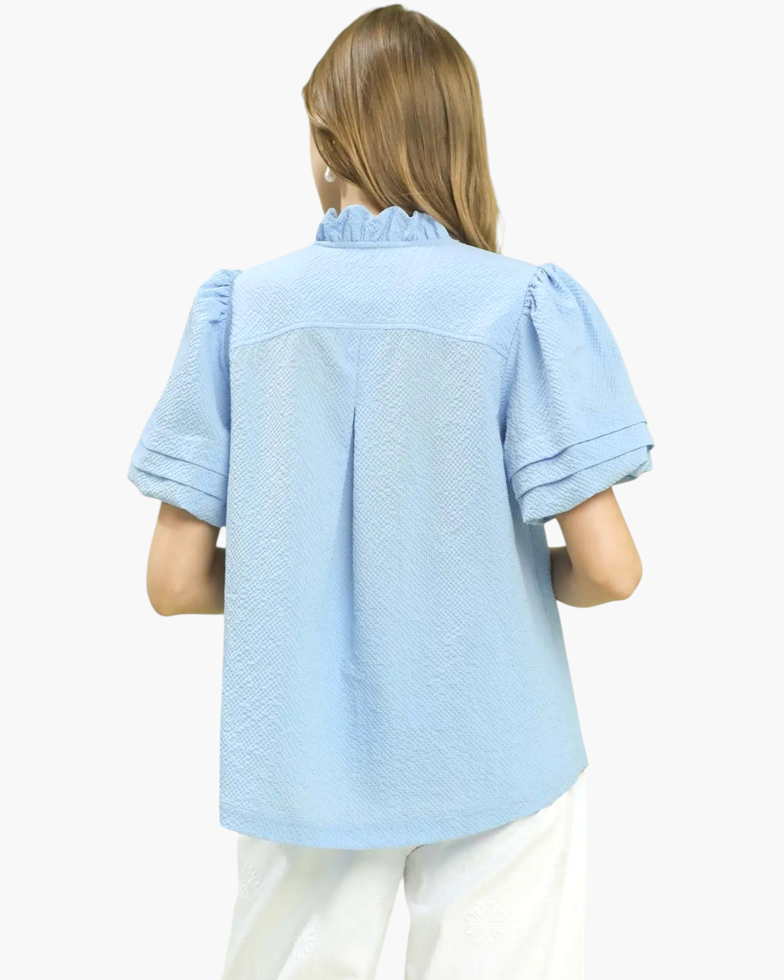 Back view of a Beach Rose Co. light blue textured blouse with a ruffled collar and puff sleeves on a model.