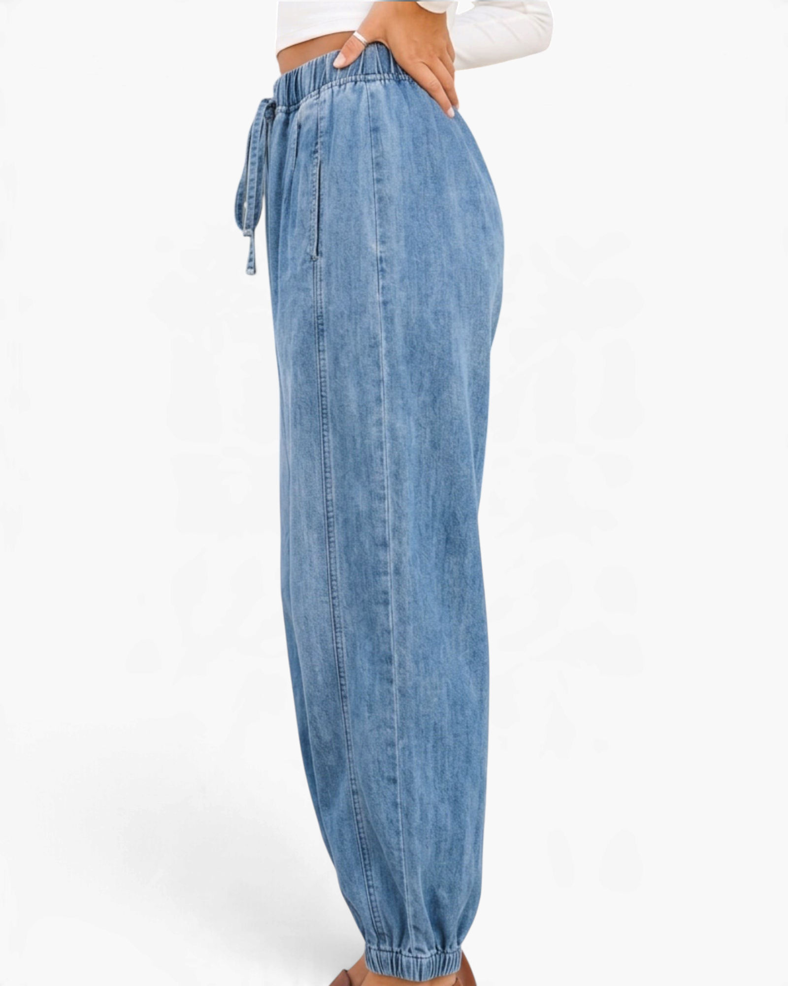 Beach Rose Co. light wash denim joggers with a drawstring waist, relaxed fit, and elastic ankle cuffs, side view.