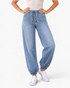 Beach Rose Co. light wash denim joggers with a drawstring waist, relaxed fit, and elastic ankle cuffs on a model.