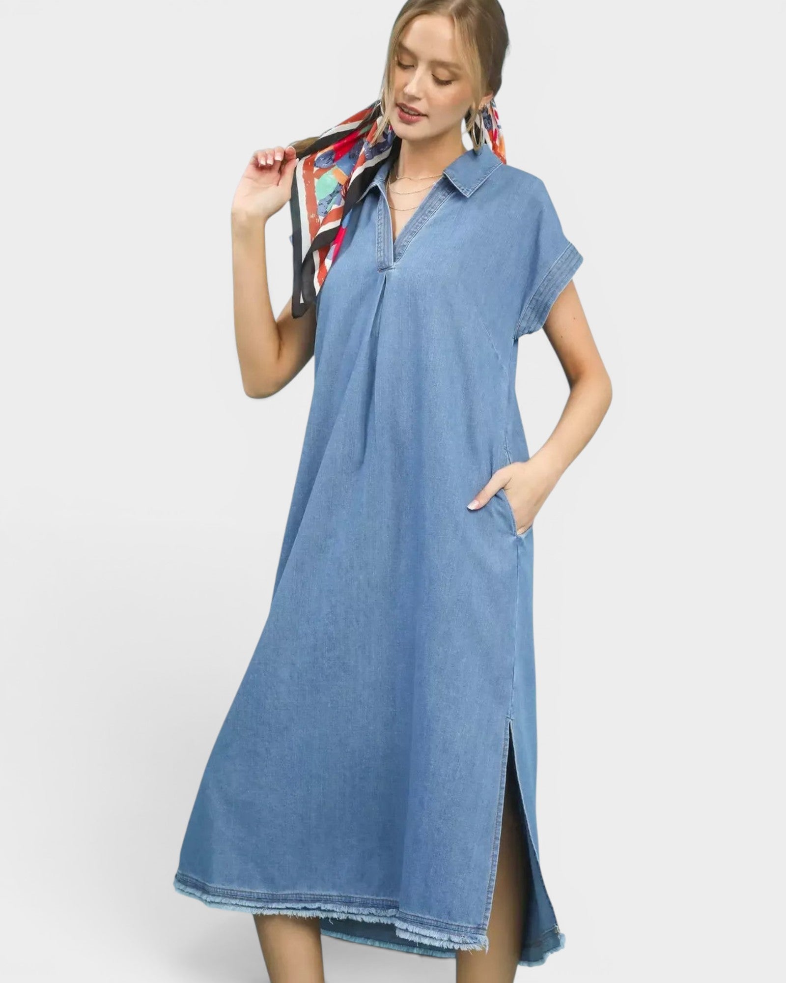 Beach Rose Co. light wash denim midi dress with collared neckline, short sleeves, side pockets, and frayed hem.