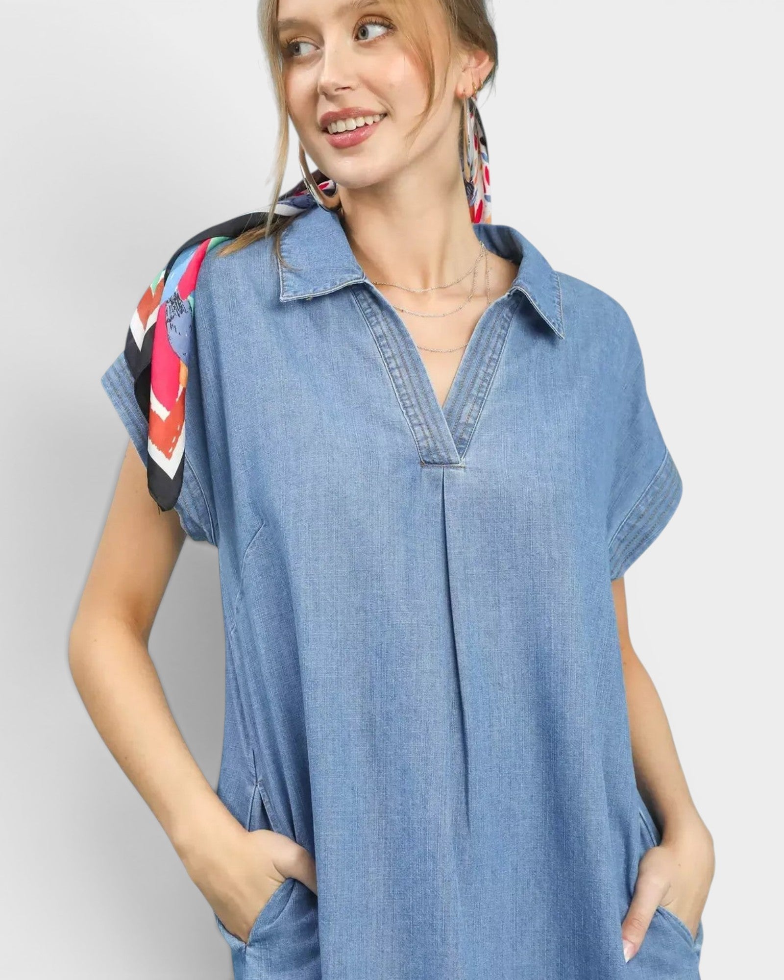 Beach Rose Co. light wash denim midi dress with collared neckline, short sleeves, side pockets, and frayed hem. Cotton blend.