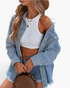 Beach Rose Co. light wash denim shirt with frayed hem worn open over a white tank top and denim shorts