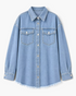 Beach Rose Co. light wash denim shirt with a pointed collar, button front, chest pockets, and a frayed curved hem.