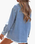 Beach Rose Co. light wash denim shirt with long sleeves and a frayed curved hem viewed from the back